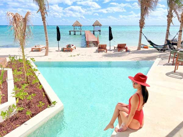 克拉拉在墨西哥图卢姆的顶级酒店之一的白色沙滩前的无边泳池的美丽景色